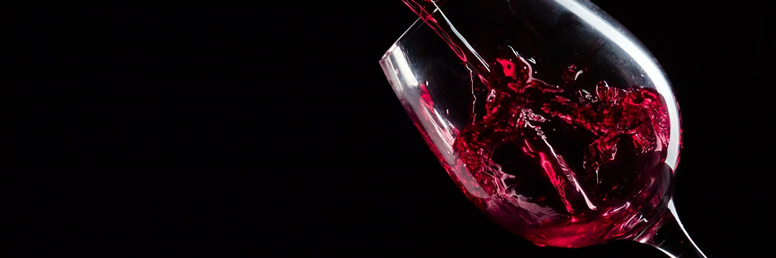 Origine Fra Rotwein im Glas auf dunklem Hintergrund.